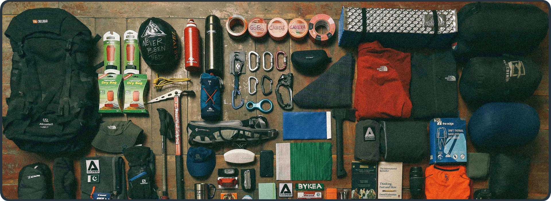 Sorgfältig sortierte Outdoor-Ausrüstung auf Holzuntergrund – Symbol für Erfahrung, Vorbereitung und Ausdauer