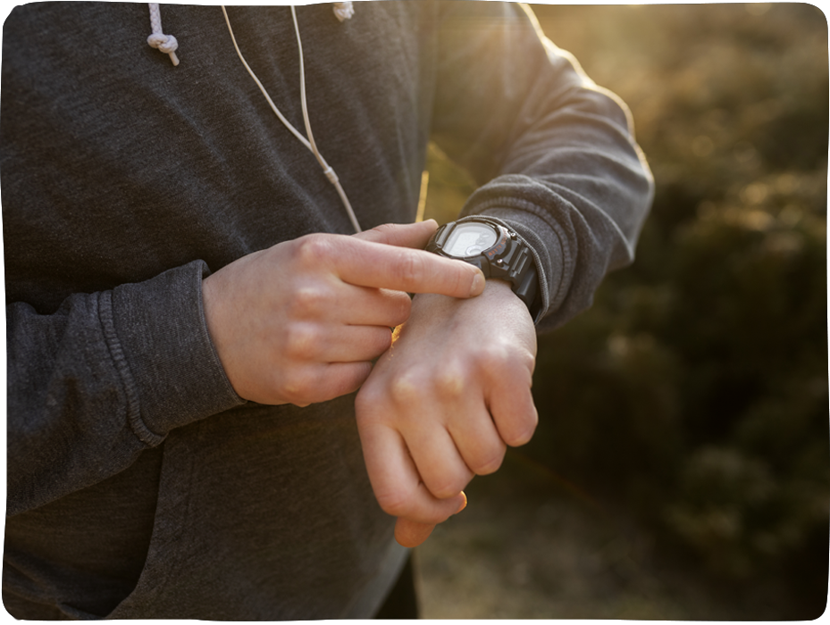 Person in Sportkleidung schaut auf ihre Armbanduhr – Symbol für Zeitplanung und Tempo im Theologiestudium
